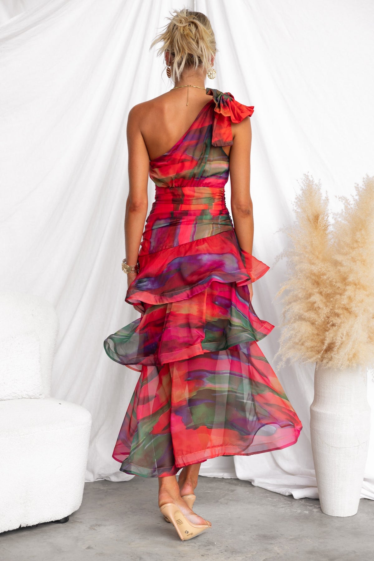 Back view of the Sherbert Midi Dress, featuring a one-shoulder neckline, ruffle hem, and vibrant multi-color design.