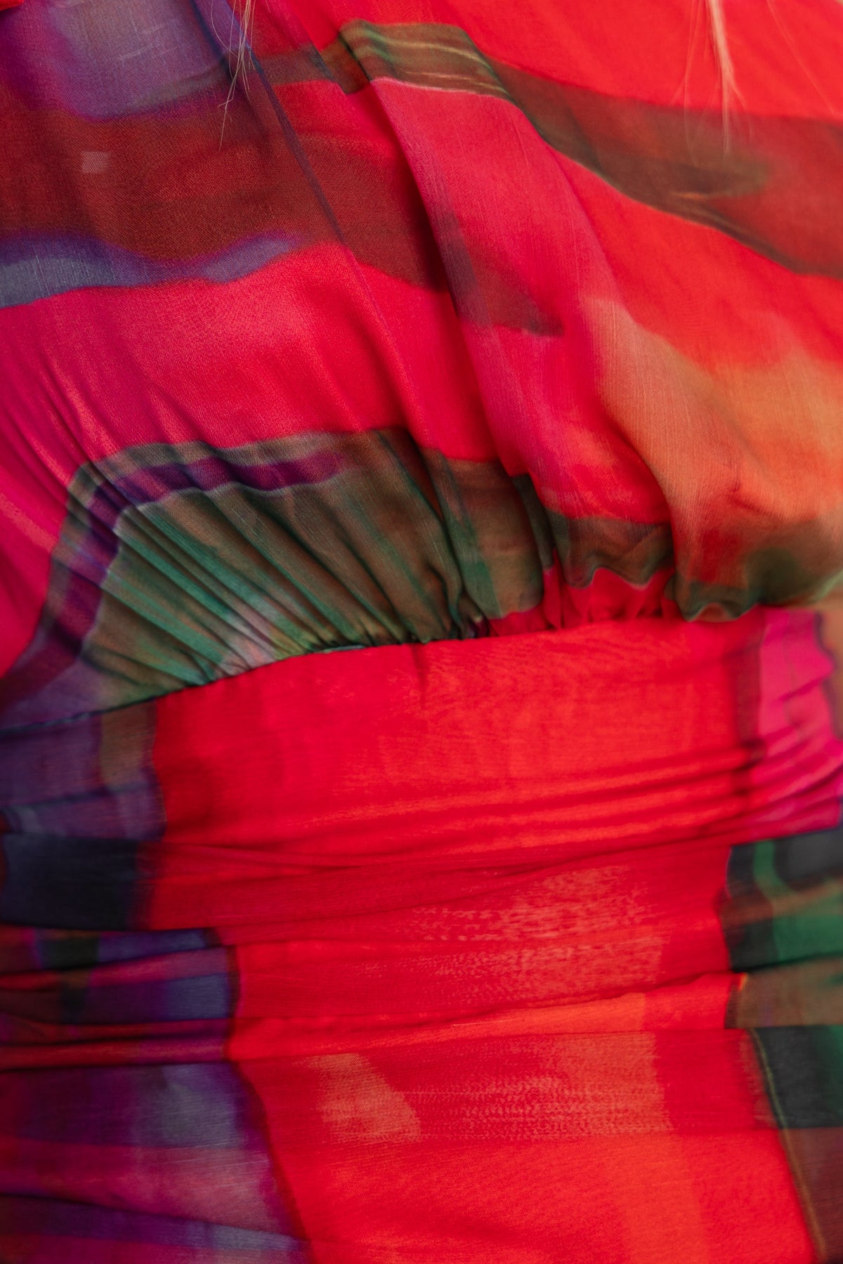 Close-up of vibrant sherbert midi dress featuring a colorful pattern and ruffle detailing in soft fabric.