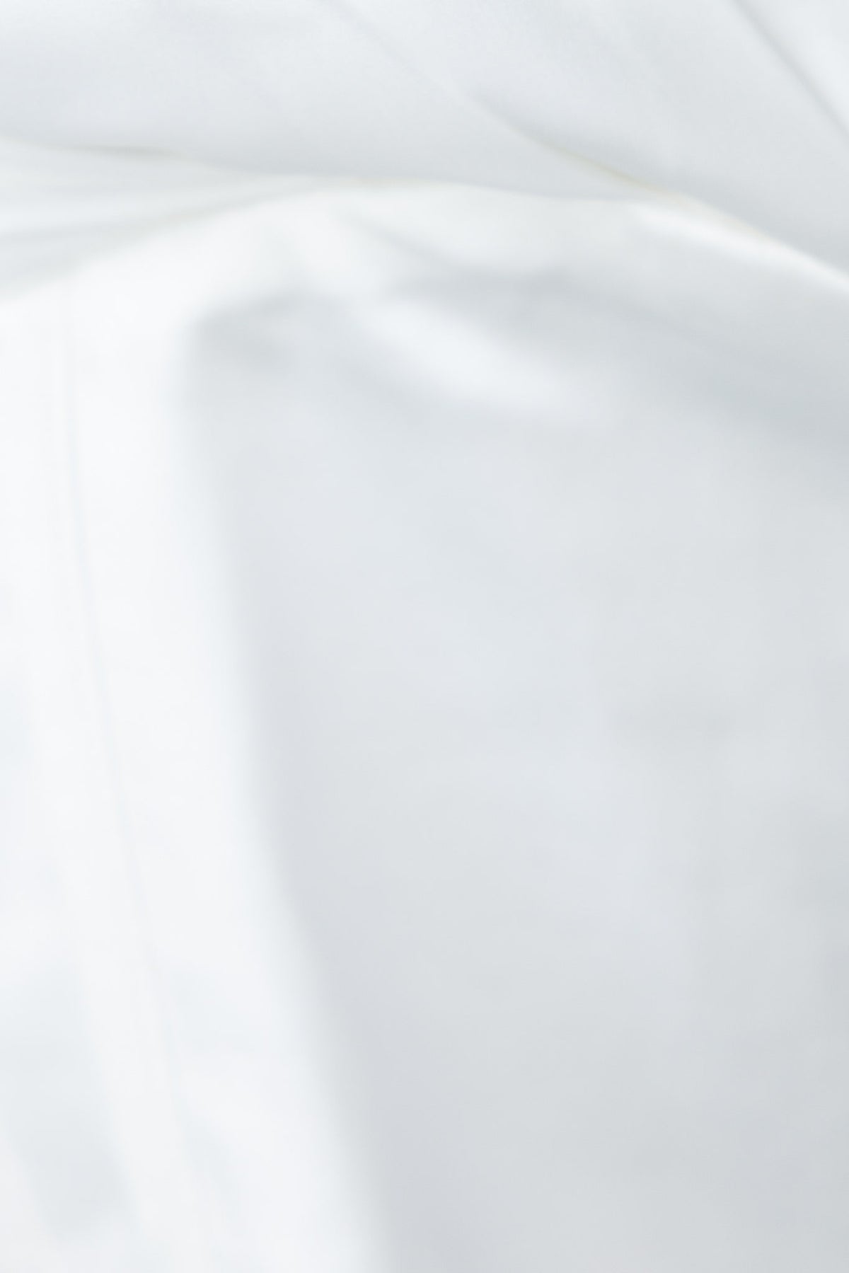 Close-up of smooth, white satin fabric, showcasing a luxurious, shiny texture.