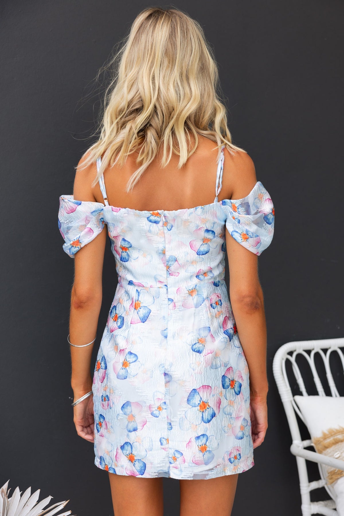 Back view of Danika Dress showcasing butterfly print, adjustable straps, and puff sleeves against a dark background.