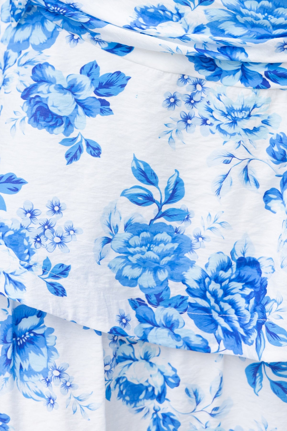 Close-up of beautiful blue floral print on white fabric, featuring ruffle detail, perfect for the Ramsey Maxi Dress.