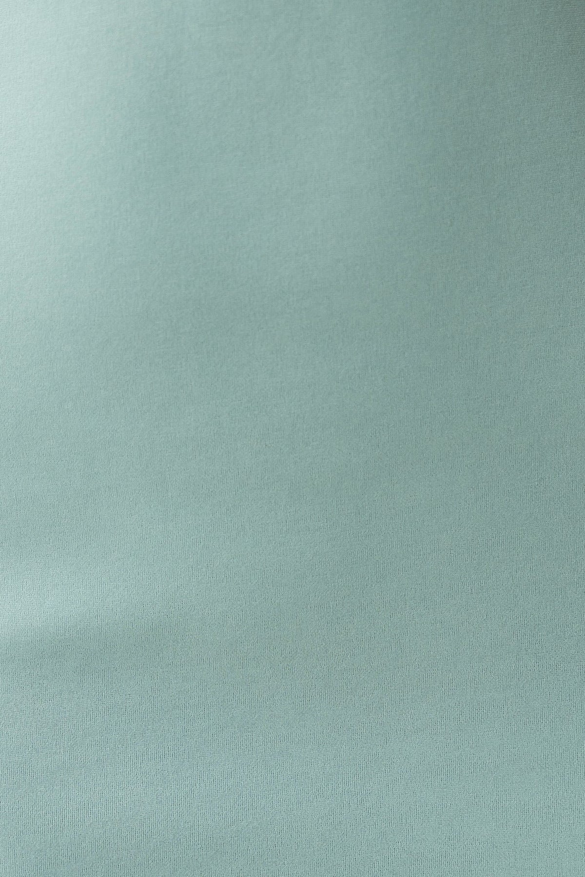 Close-up of smooth mint green fabric texture, showing softness and stretch, perfect for stylish apparel.
