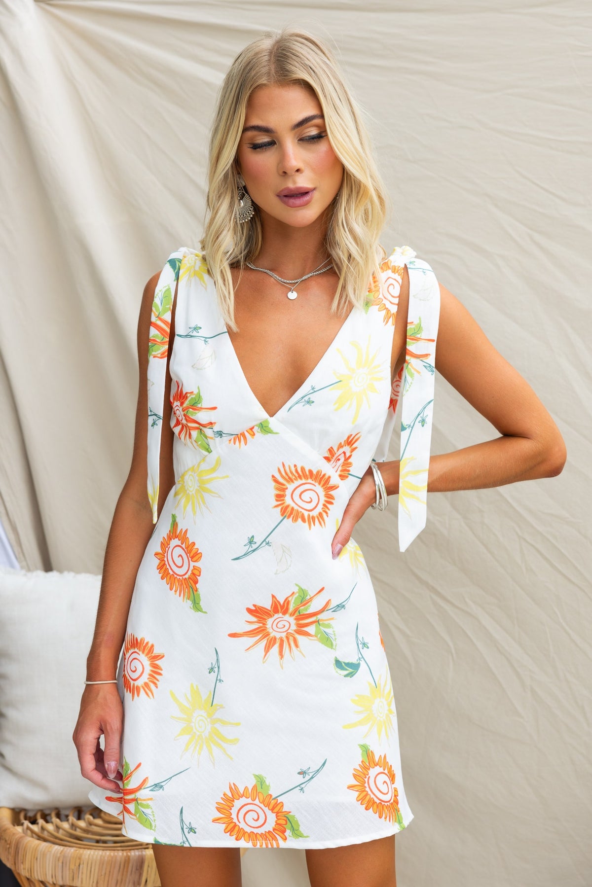Model wearing Kinsey Dress with floral print, adjustable tie straps, and a stylish V-neckline.
