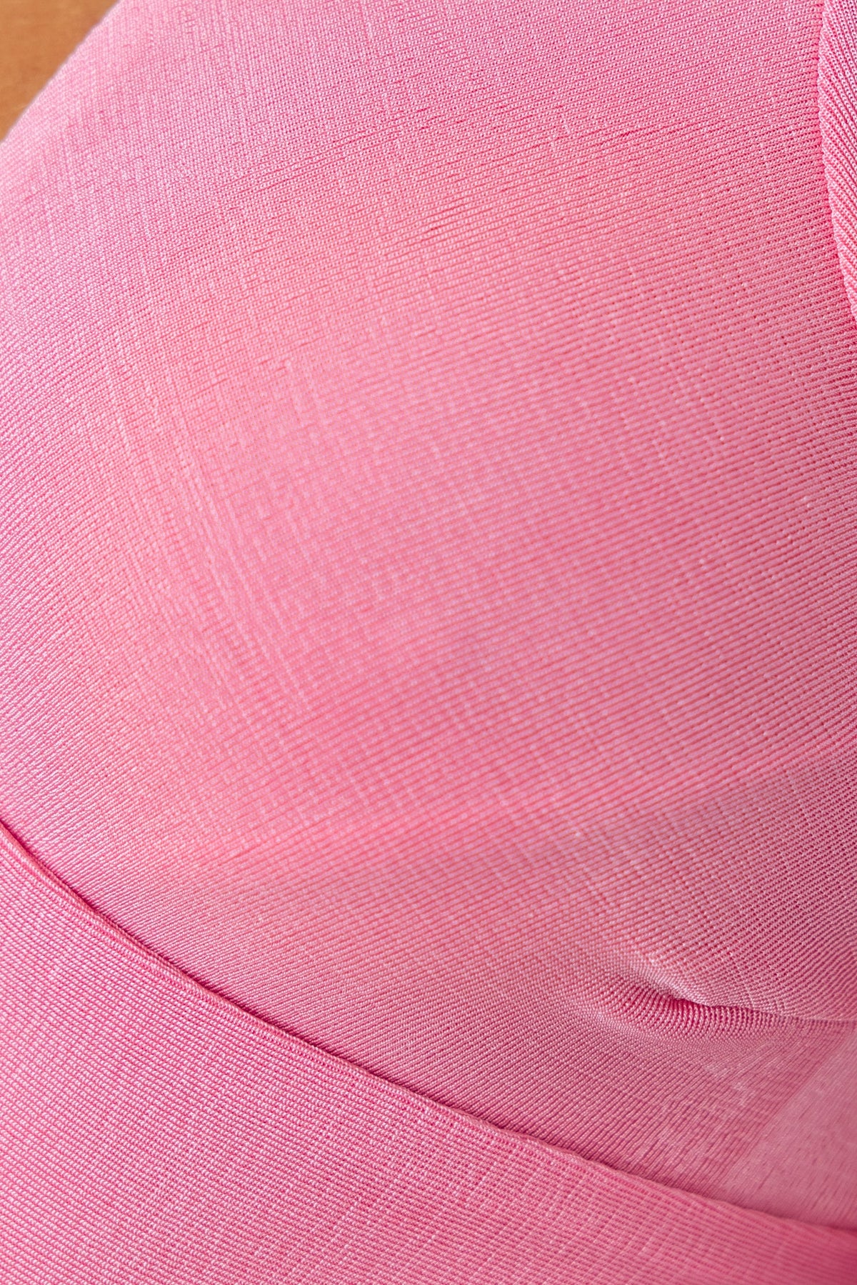 Close-up of the pink fabric texture of the Elias Top, featuring a slinky material with stretch.