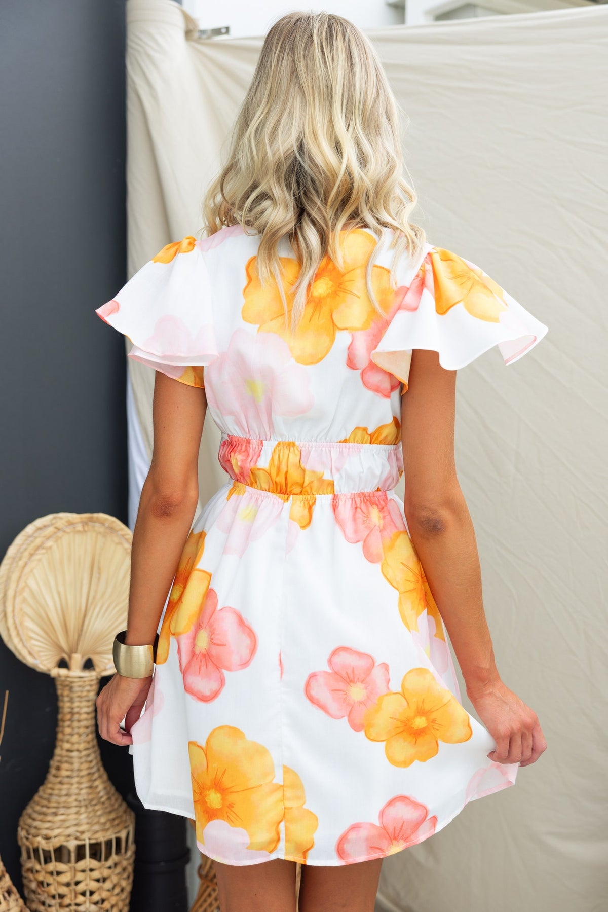 Back view of Milene Dress featuring floral print, V-neckline, and tie detail at bust.