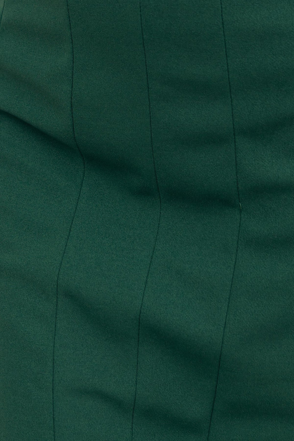 Close-up of the textured fabric in a deep green color, showcasing subtle stitch lines in a fitted dress design.