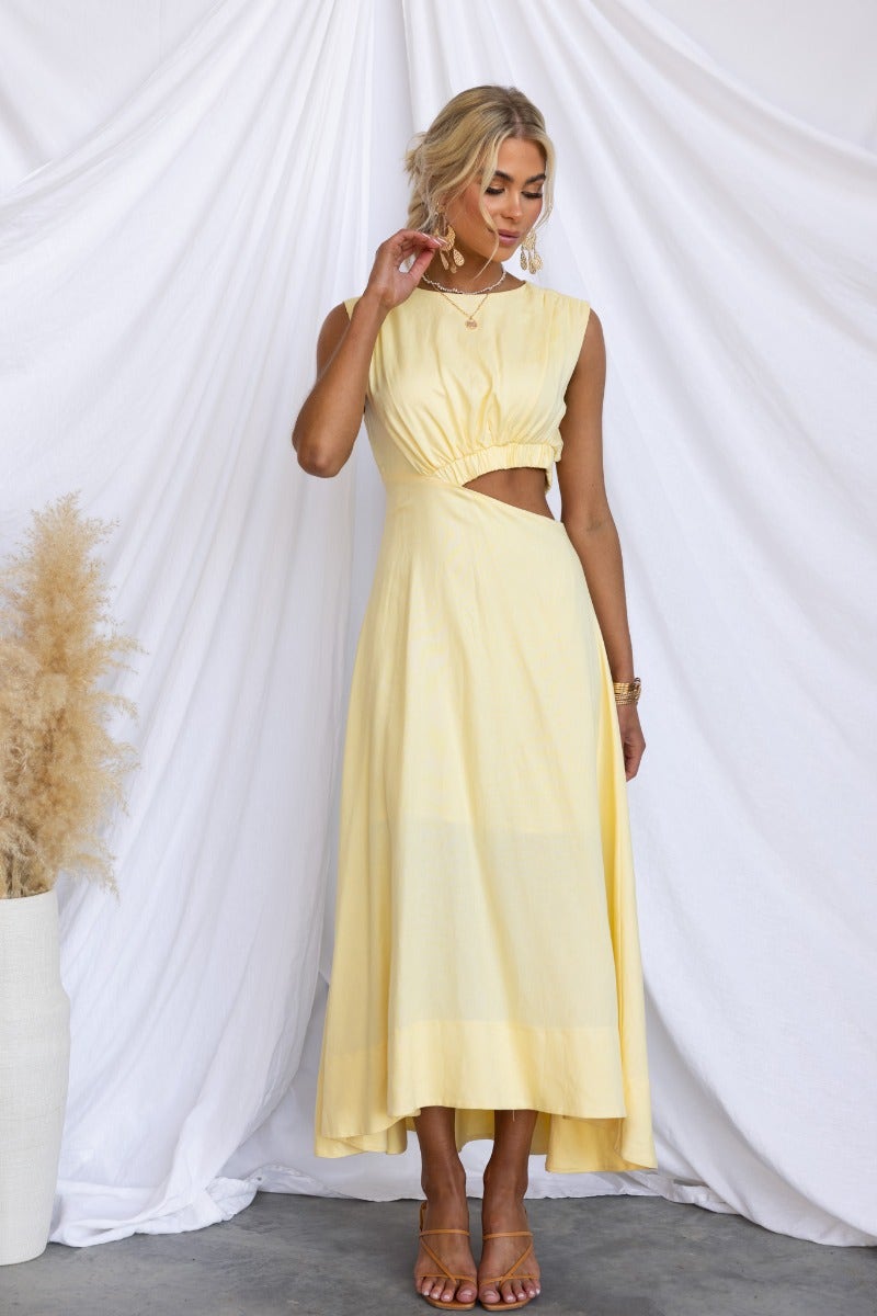 Model wearing Inspire You Maxi Dress in yellow, showcasing high neckline, elastic cut-out waist, and flowing design.
