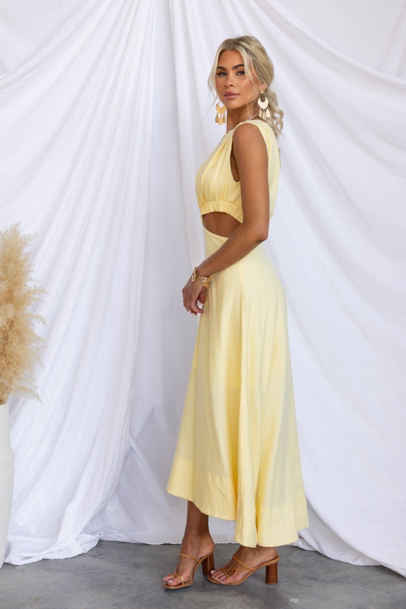 Model wearing Inspire You Maxi Dress in yellow, featuring a high neckline and elastic cut-out at the waist.