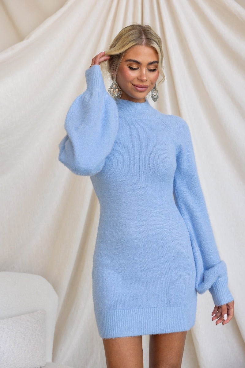 Model wearing Arise Dress in fluffy yarn, featuring high neckline and balloon sleeves in soft blue color.