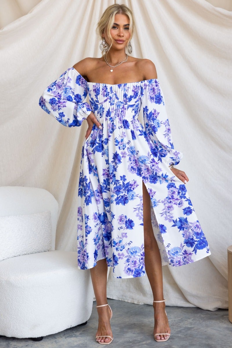 Lost Love Midi Dress in floral print with off-shoulder design, front split, and pleat details, styled in a bright setting.