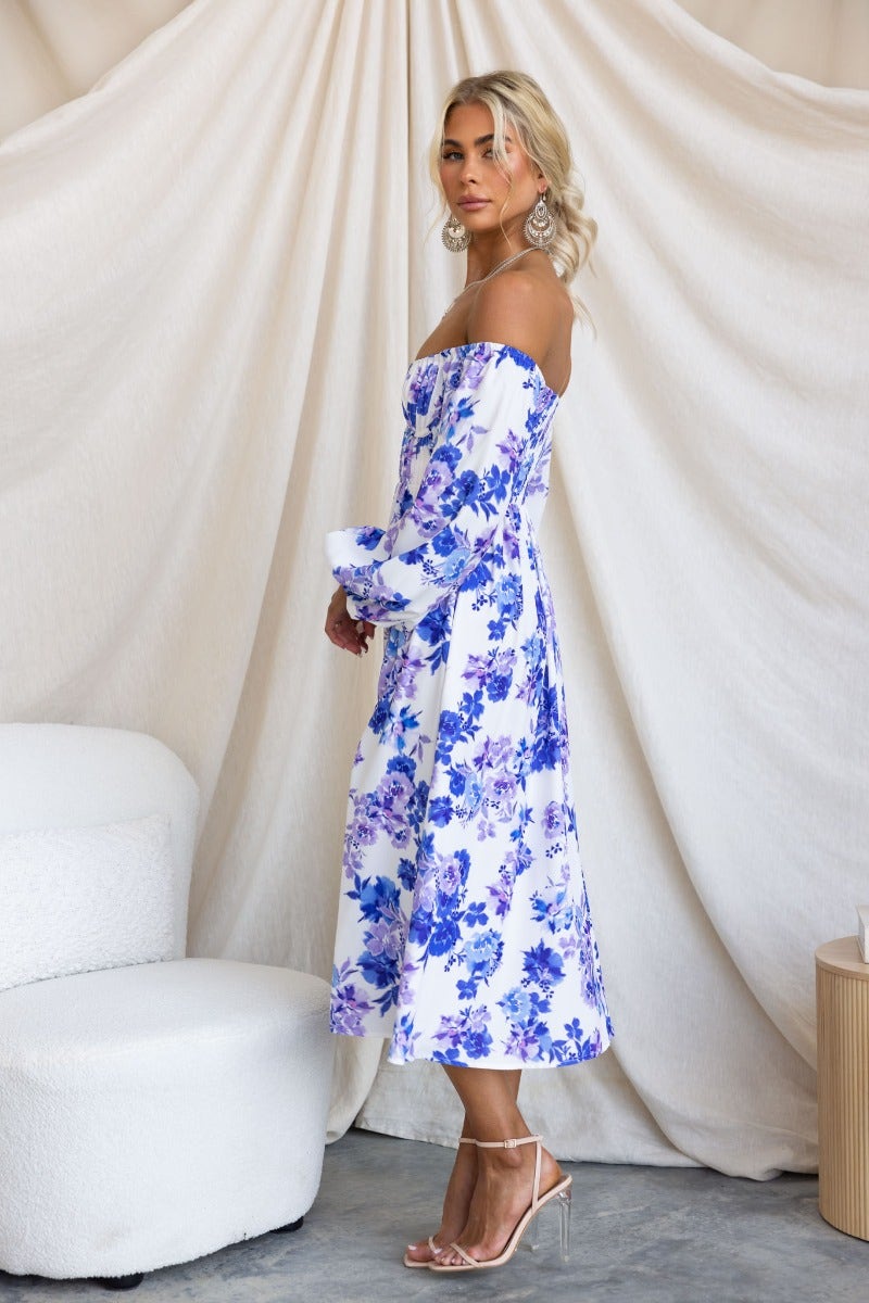 Side view of a model wearing the Lost Love Midi Dress with floral print, off-shoulder design, and pleated bust detail.