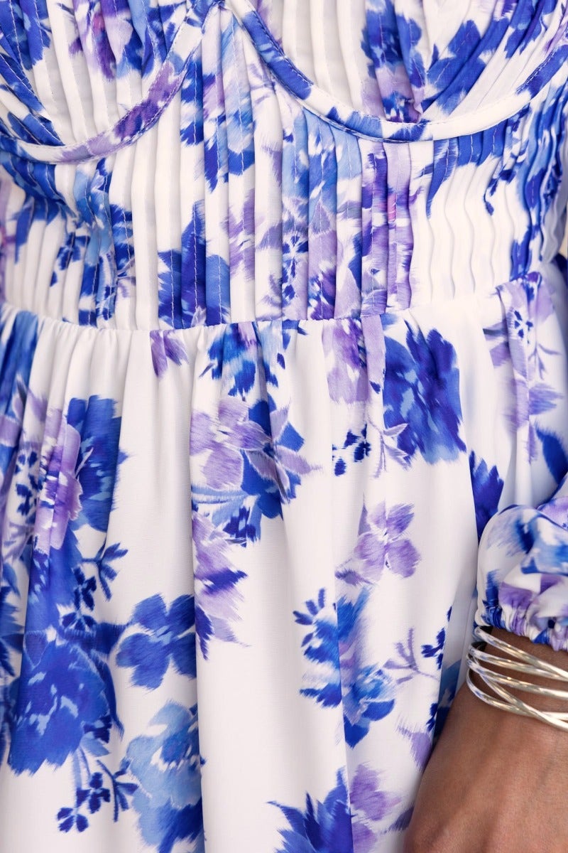 Close-up of the Lost Love Midi Dress featuring a beautiful blue floral print and pleat detailing.