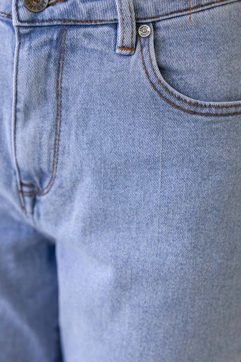 Close-up of Dori mom jeans featuring a mid-high waist fit and light blue denim with front pockets.