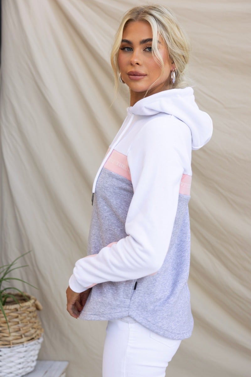 Xarles Jumper hoodie in grey and pink with drawstring, ribbed sleeves, and scoop hemline, showcased on model.