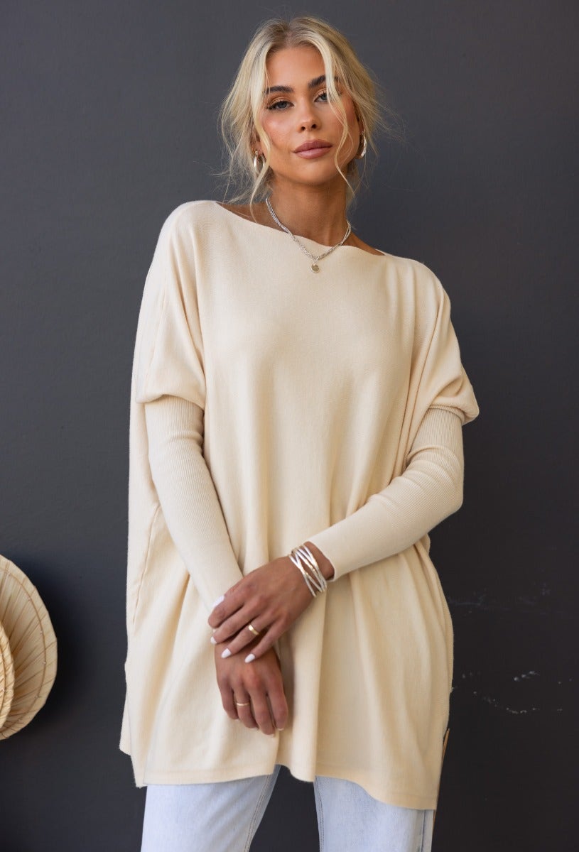 Woman wearing the Bonnie Knit oversized top in beige, featuring full-length sleeves and a cozy, relaxed fit.