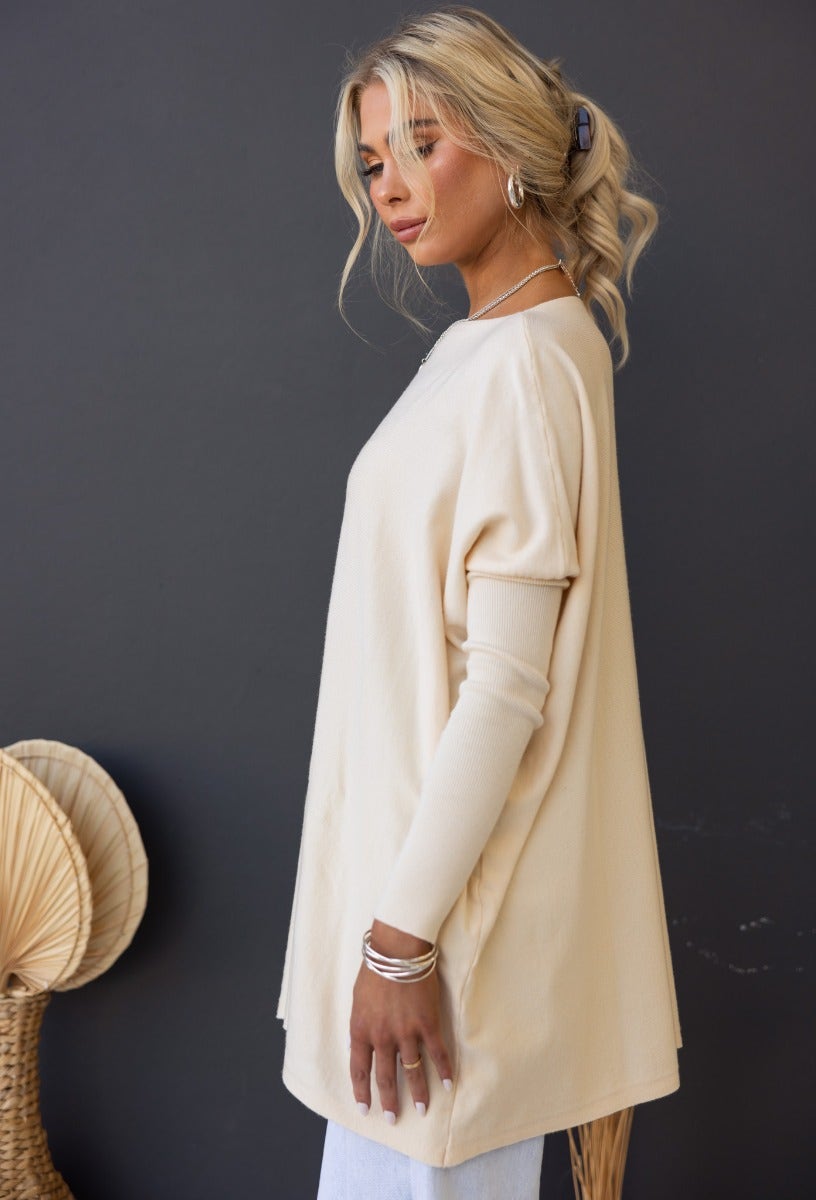 Model showcasing the Bonnie Knit oversized top in beige, featuring full-length sleeves and a relaxed fit.