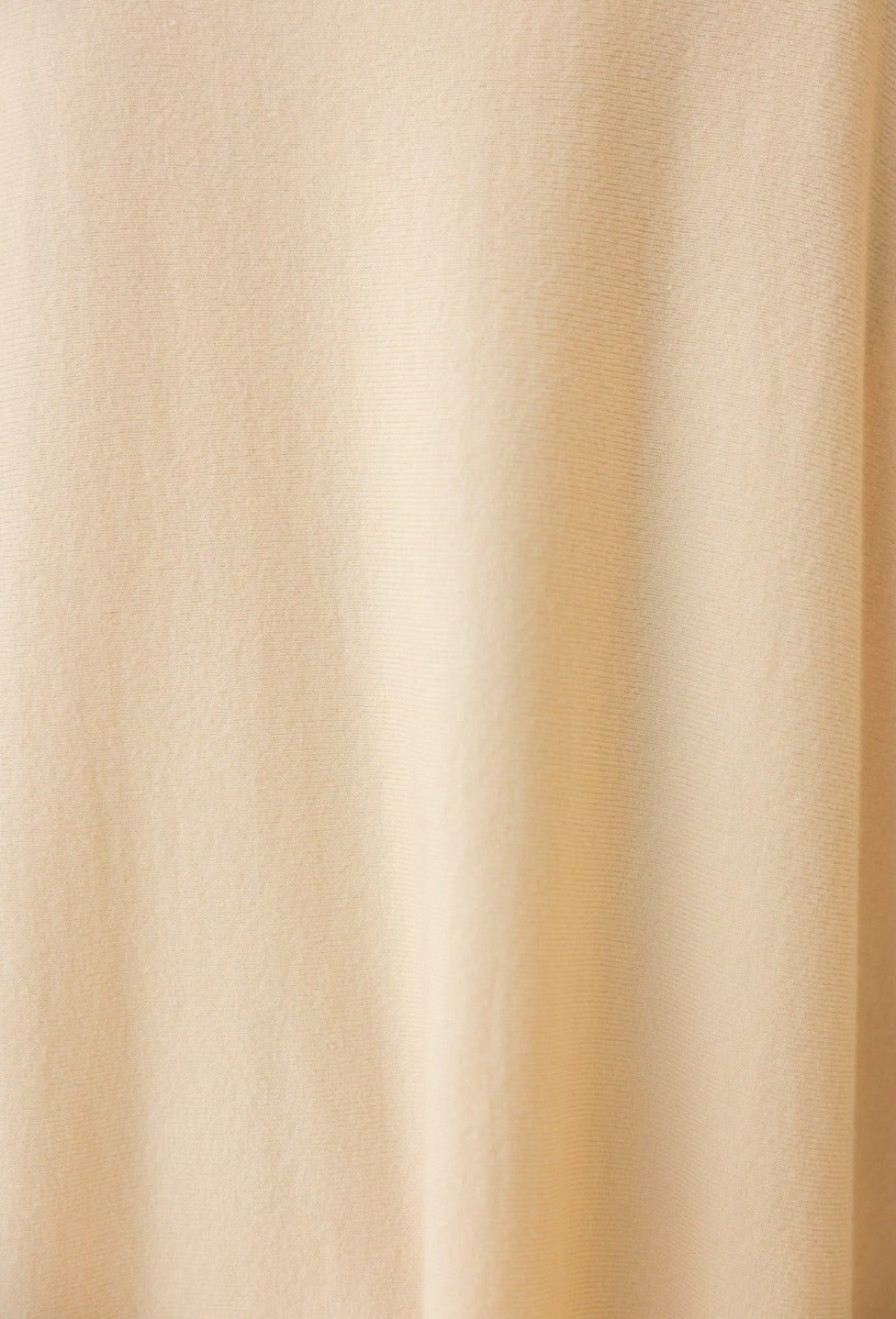 Close-up of soft beige fabric showing the texture, suitable for cozy oversized tops or dresses.
