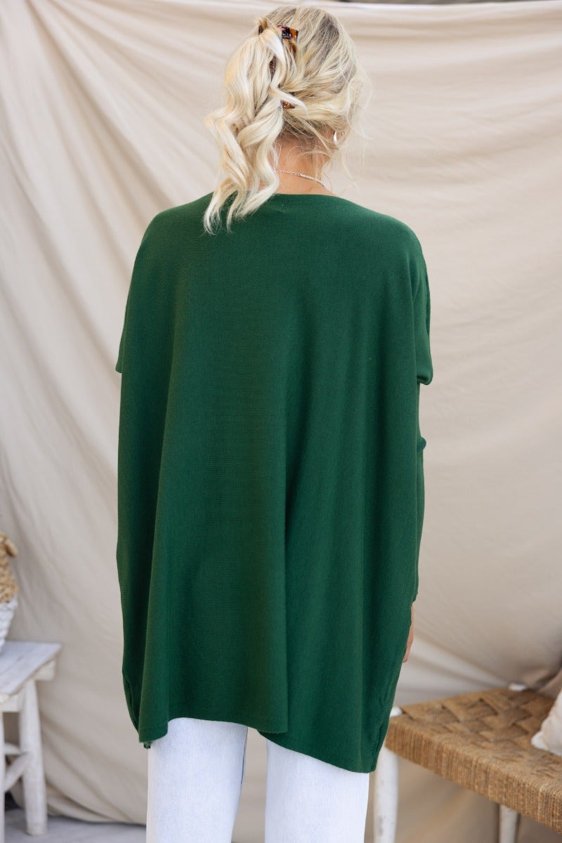Back view of a woman wearing a cozy oversized green Bonnie Knit top, showcasing full-length sleeves and an oversized fit.