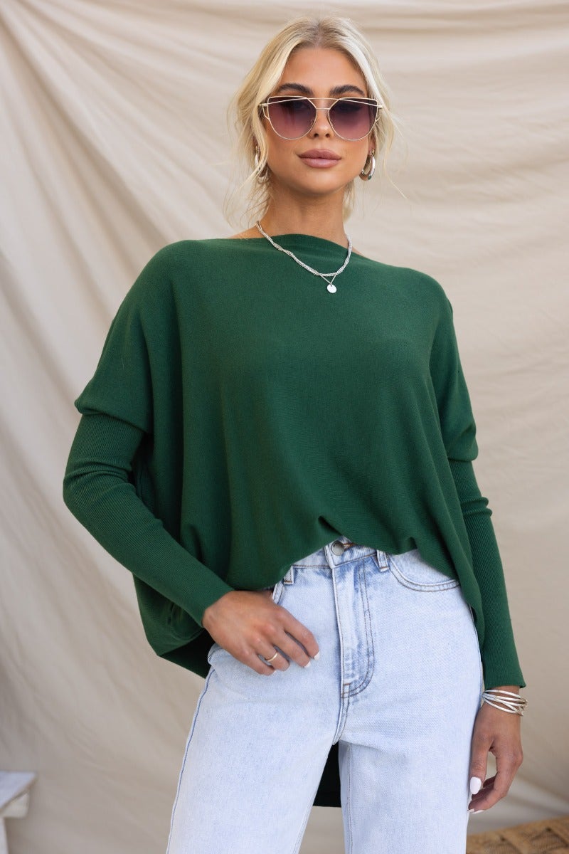 Model wearing a cosy oversized green knit top with full-length sleeves and stylish sunglasses.