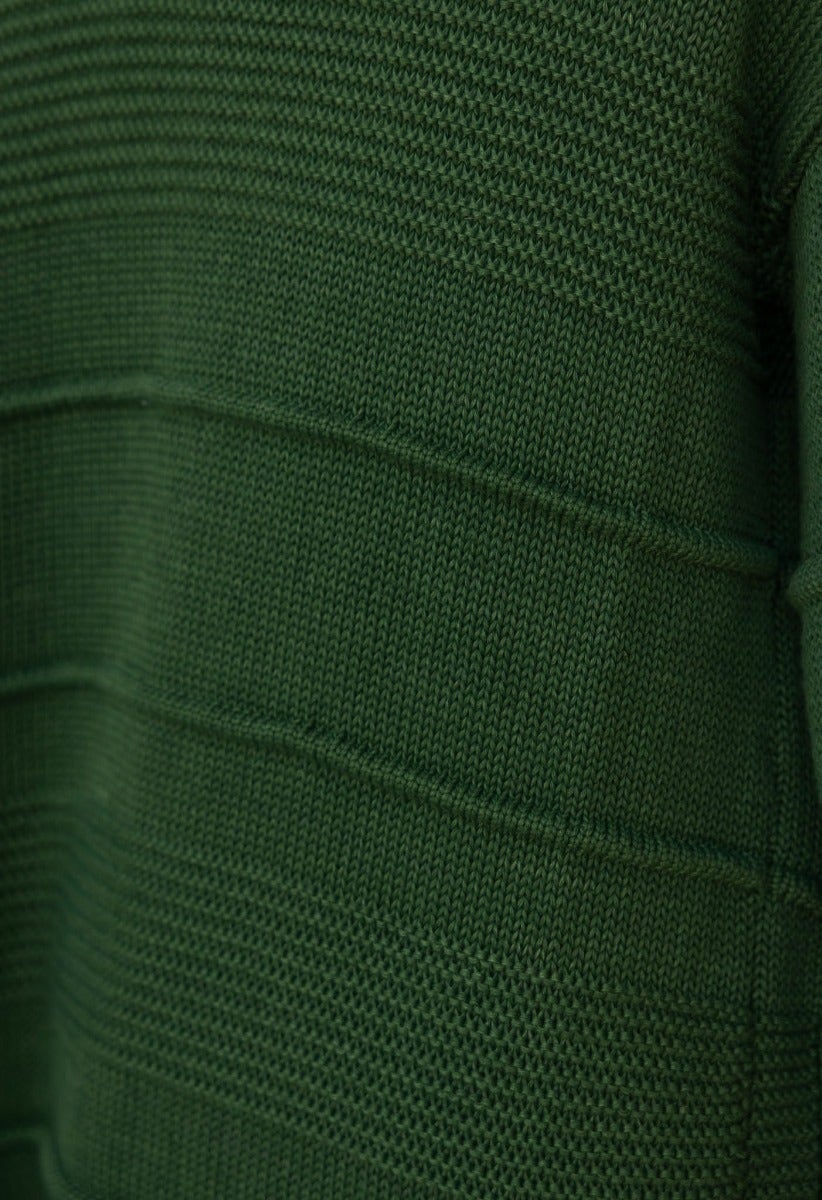 Close-up of Zeddie Cardigan fabric, showcasing green knit texture and pattern details.