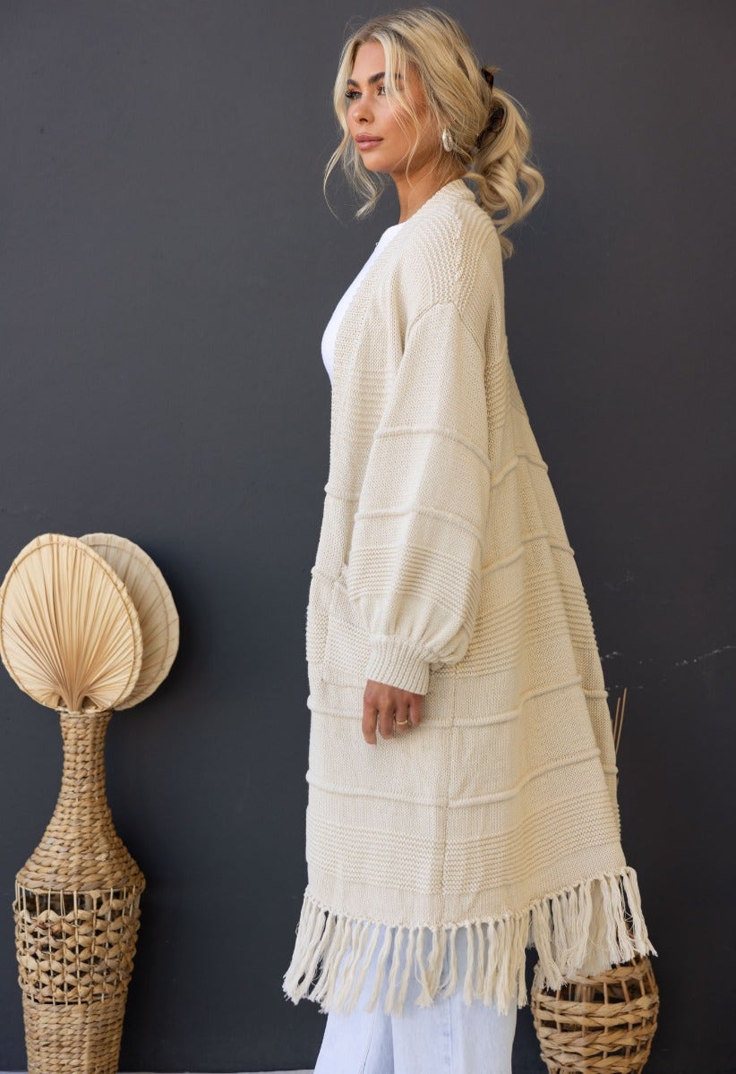 Zeddie Cardigan in cream, longline knit style with pockets and fringe, perfect for a relaxed fit.