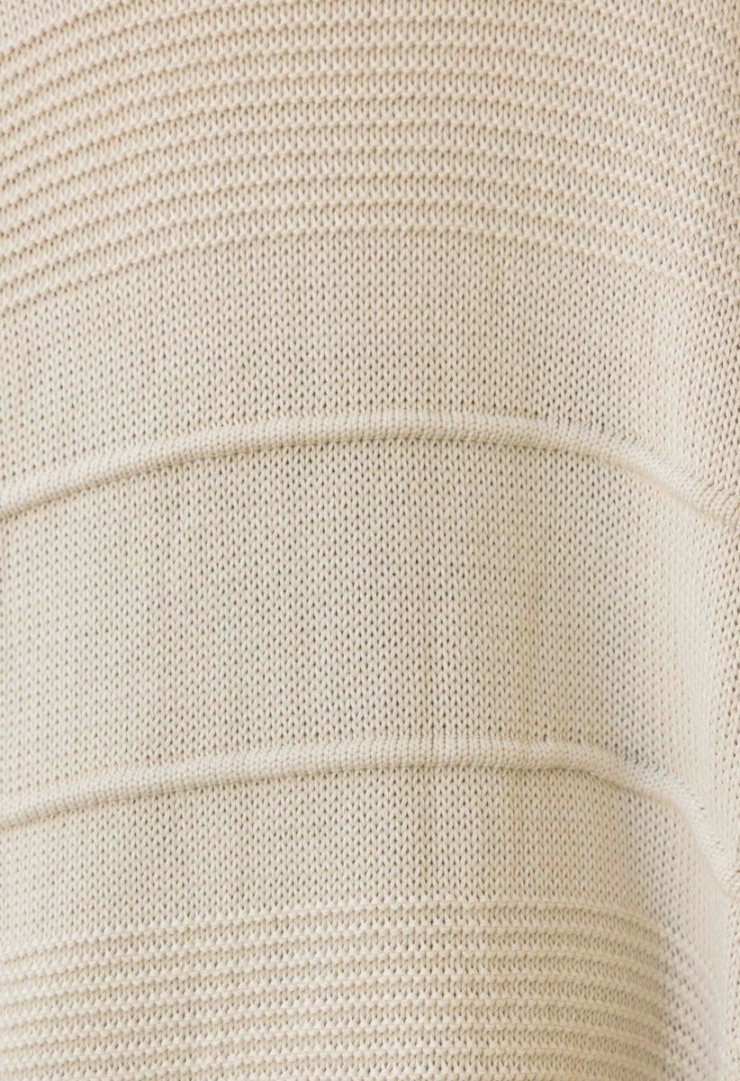 Close-up of Zeddie cardigan fabric showing textured knit design in beige tones.