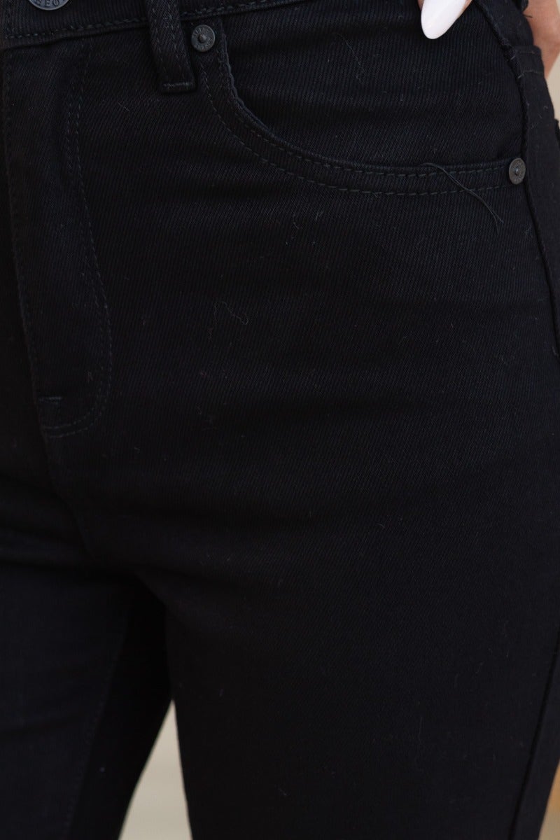 Close-up of Rueben Mom Jeans in black denim, featuring front pockets and mid-high waist fit.
