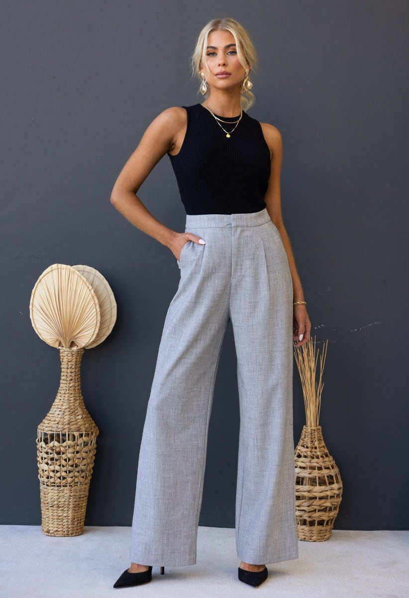 Model wearing grey Kodi pants with wide legs and high waist, styled with a black top and accessories.