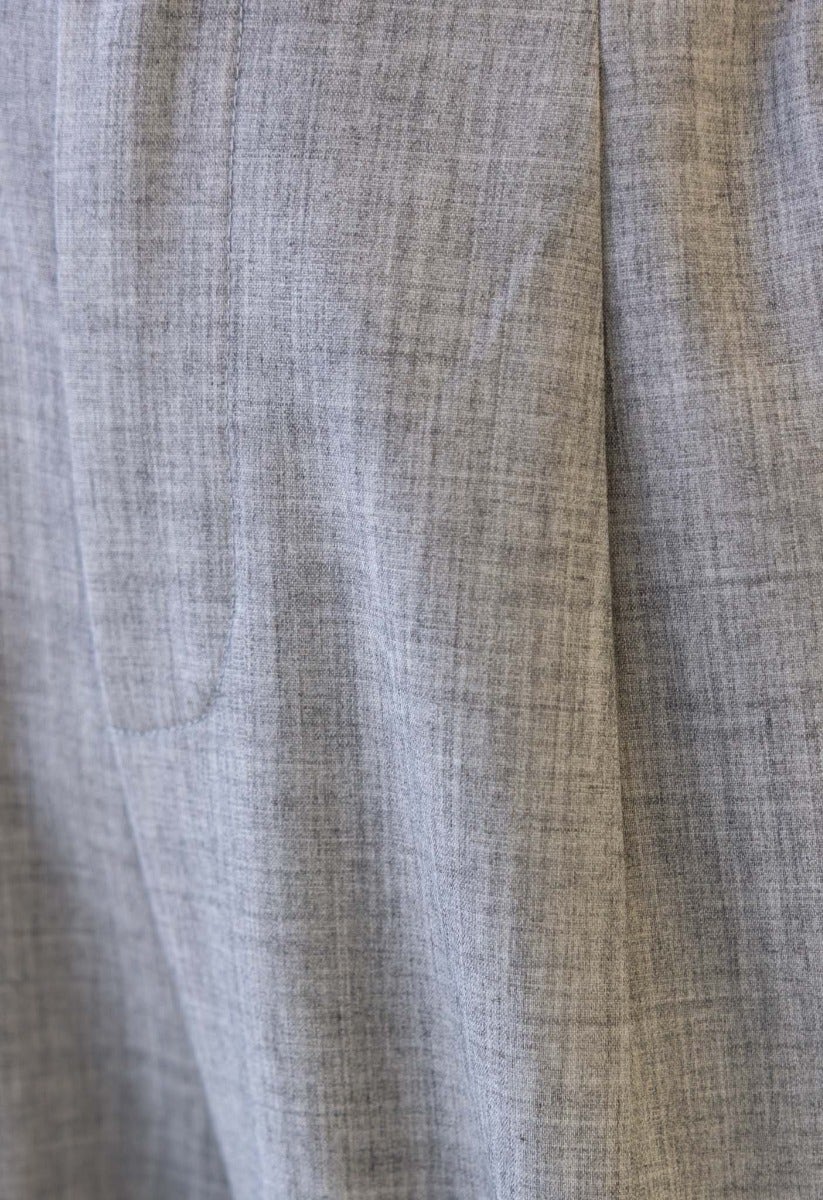 Close-up of Kodi Pants showing the textured grey fabric, mid-high waist fit, and front pocket details.