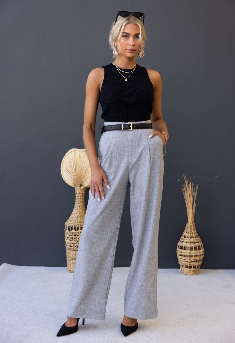 Model wearing Kodi Pants in gray with wide legs, high waist, styled with a black top and accessories.