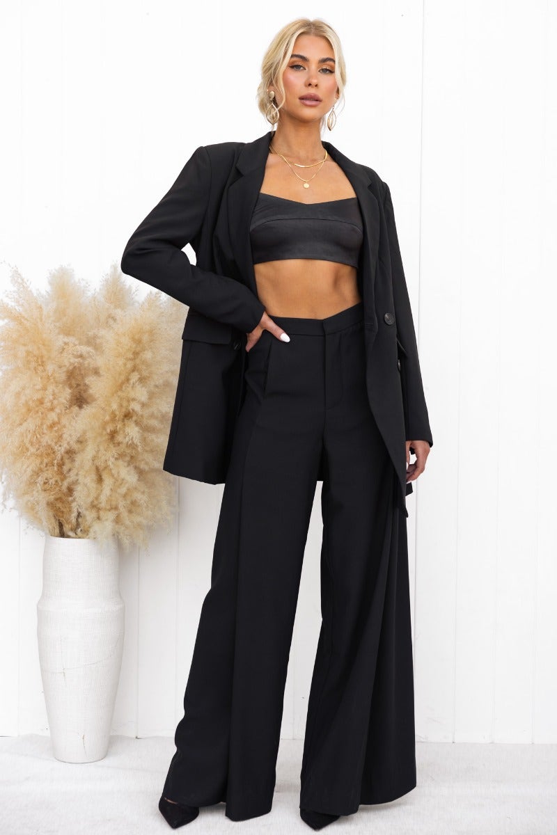Model wearing Estel Blazer with wide-leg pants and cropped top, styled with faux pockets and shoulder pads.