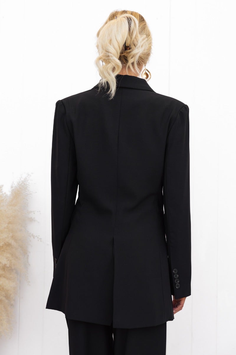 Back view of a stylish black Estel blazer featuring shoulder pads and a split back design.