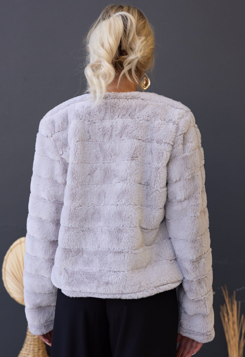 Back view of the grey Aviana faux fur jacket, showcasing its soft texture and standard fit, perfect for stylish layering.