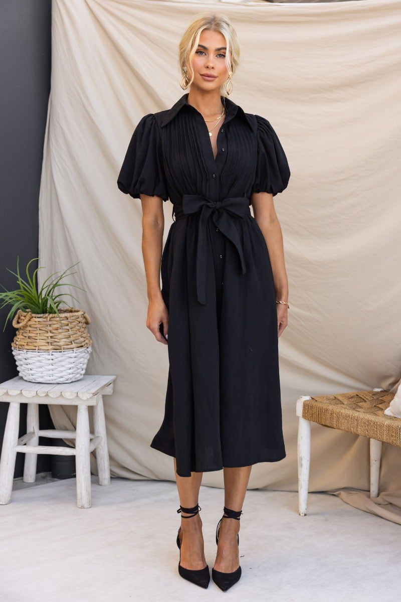 Elegant black Sorrento Midi Dress featuring high neckline, button-up front, and removable belt.