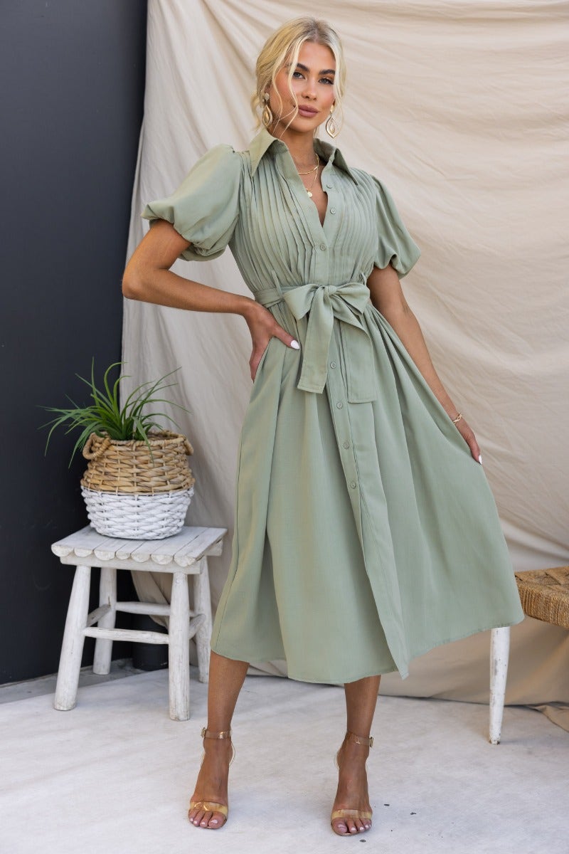 Sorrento Midi Dress in green with high neckline, button-up front, and removable belt styled casually.