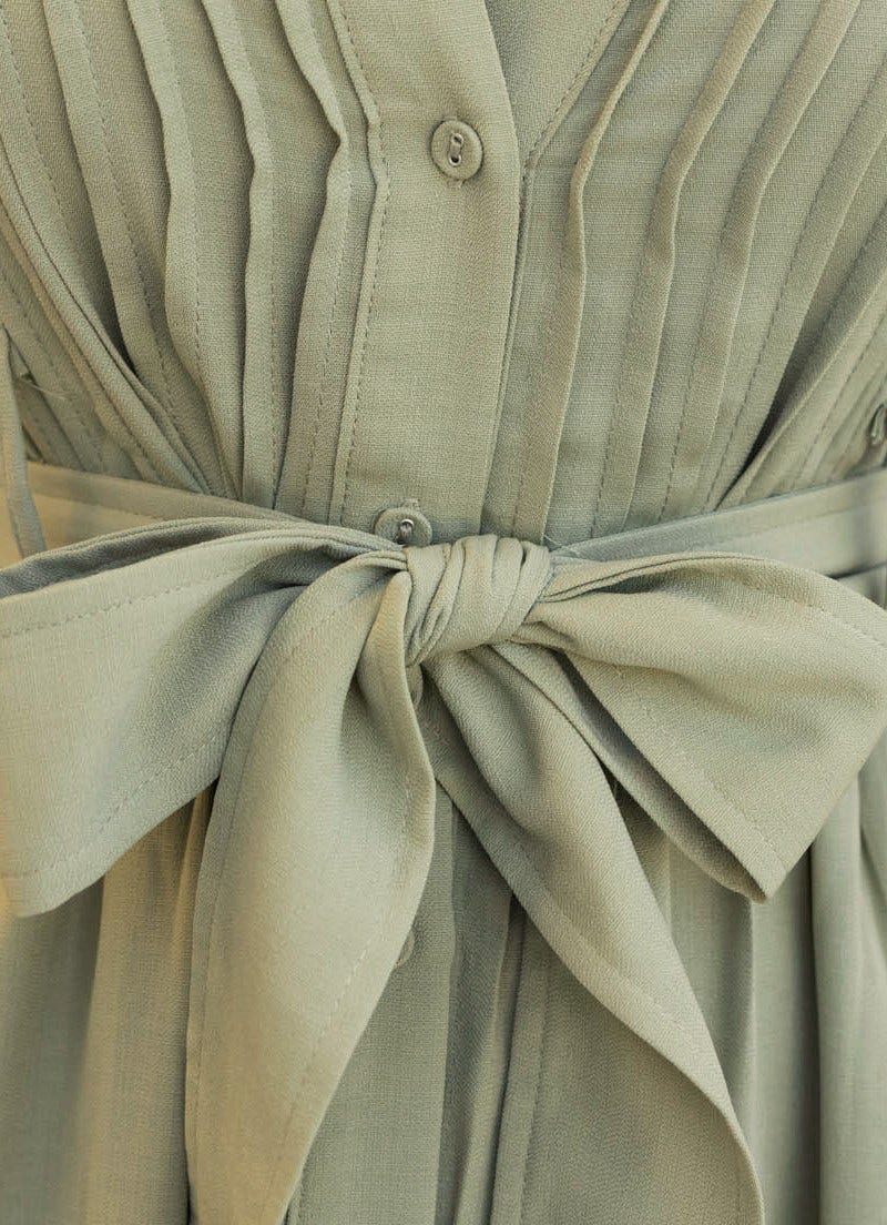 Close-up of Sorrento Midi Dress showcasing pleats, button-up front, and removable fabric belt detail.