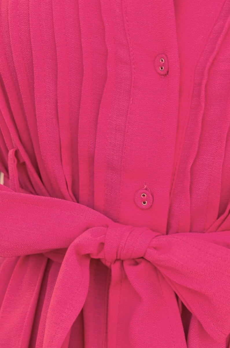 Close-up of Sorrento Midi Dress featuring vibrant pink fabric, button front, and tied waist belt.