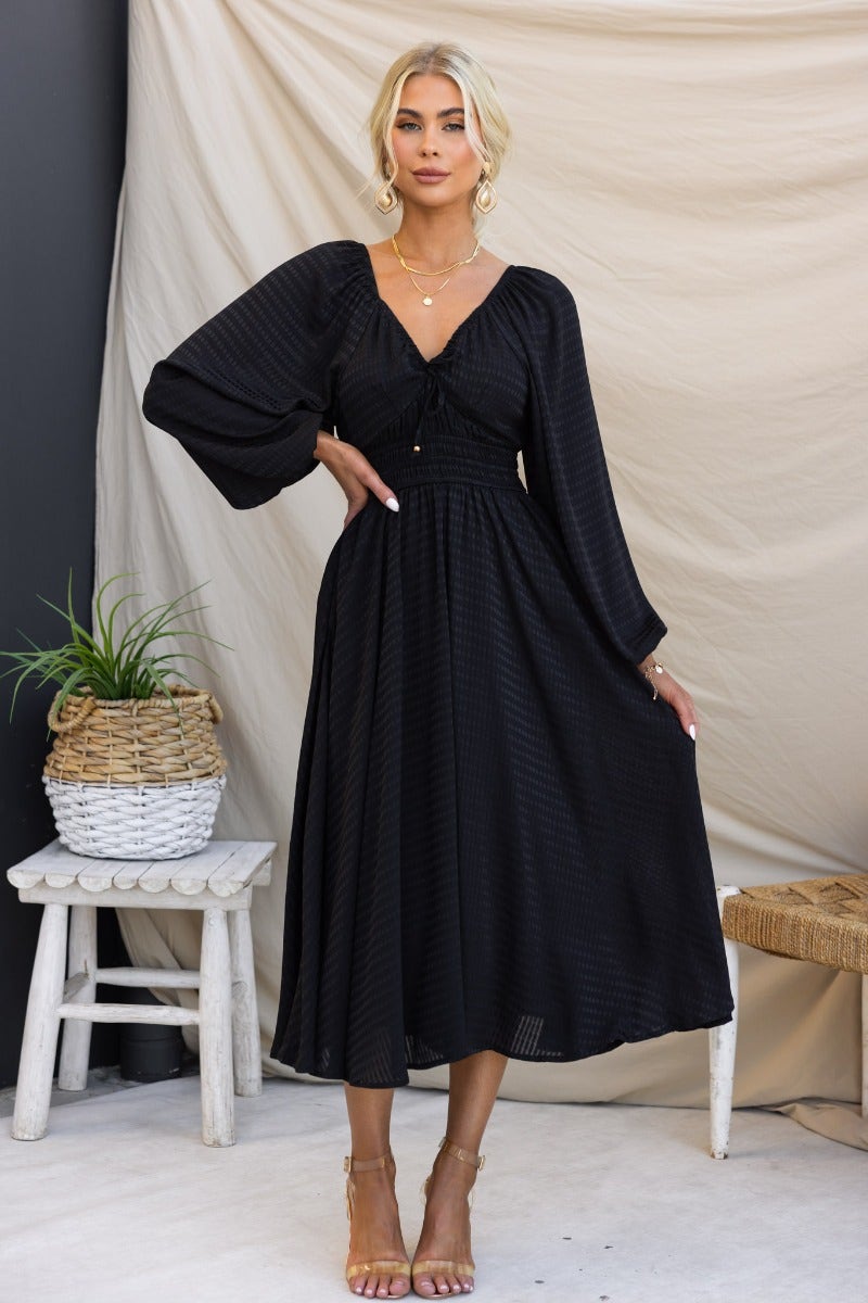 Hemingway Midi Dress in black, featuring elastic sleeve and neckline fittings, tie detail, and pockets.