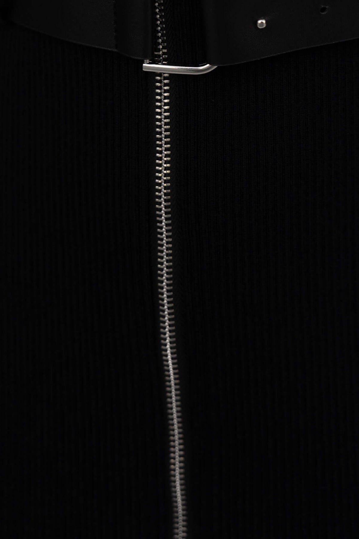 Close-up of the Rawlins Dress showing the zip-up front and removable belt in ribbed black material.