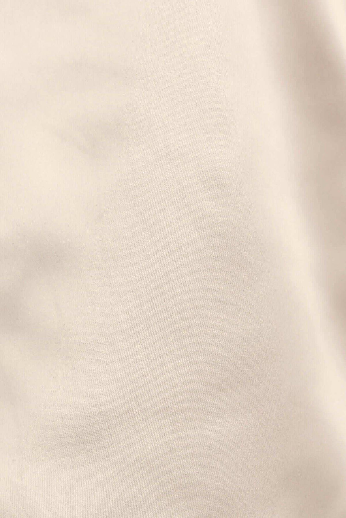 Close-up of the smooth, satin-like fabric of the Tanaya Top in a neutral beige color.