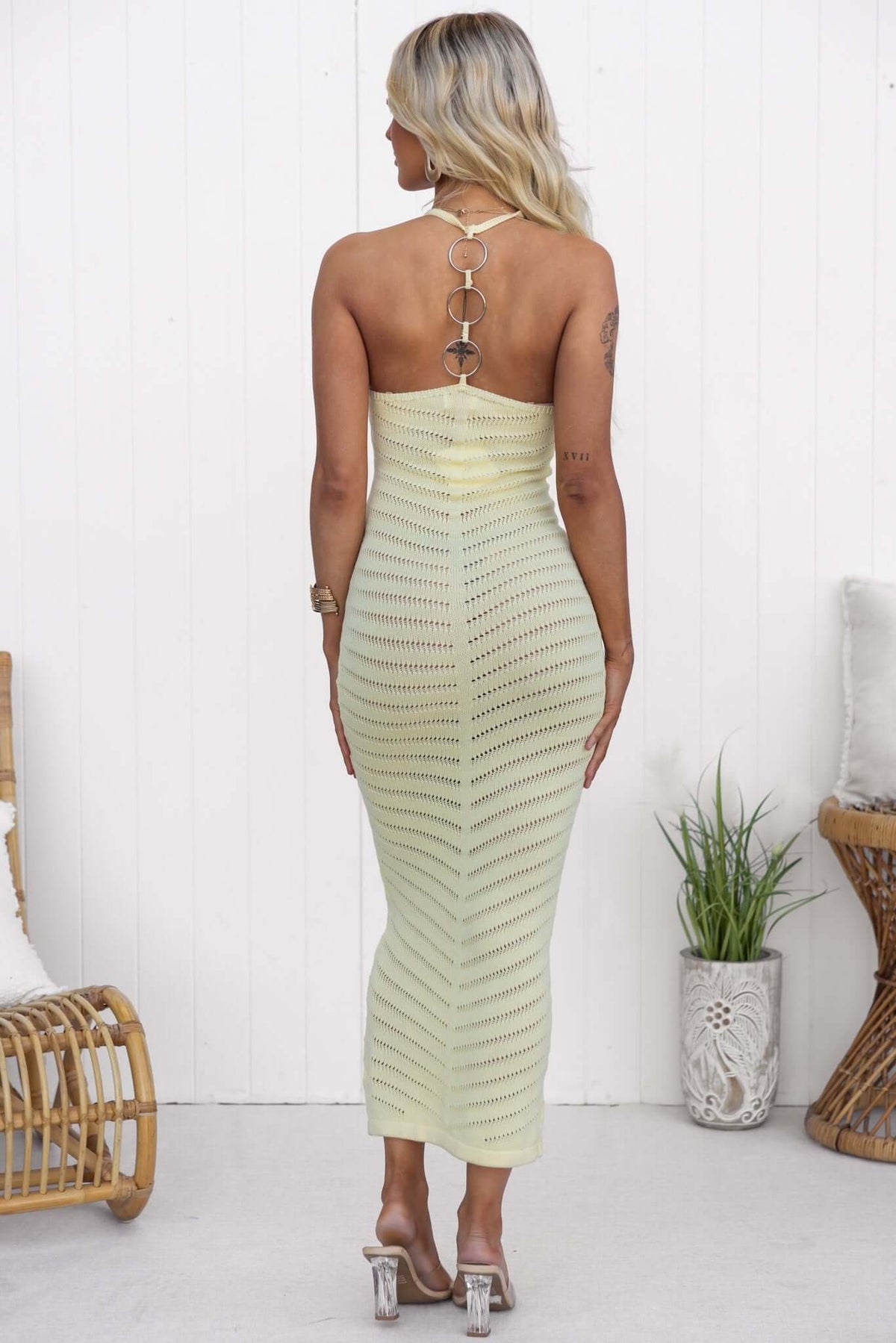 Back view of the Ventura Maxi Dress featuring a high neckline, ring detail, and open weave design in soft yellow.