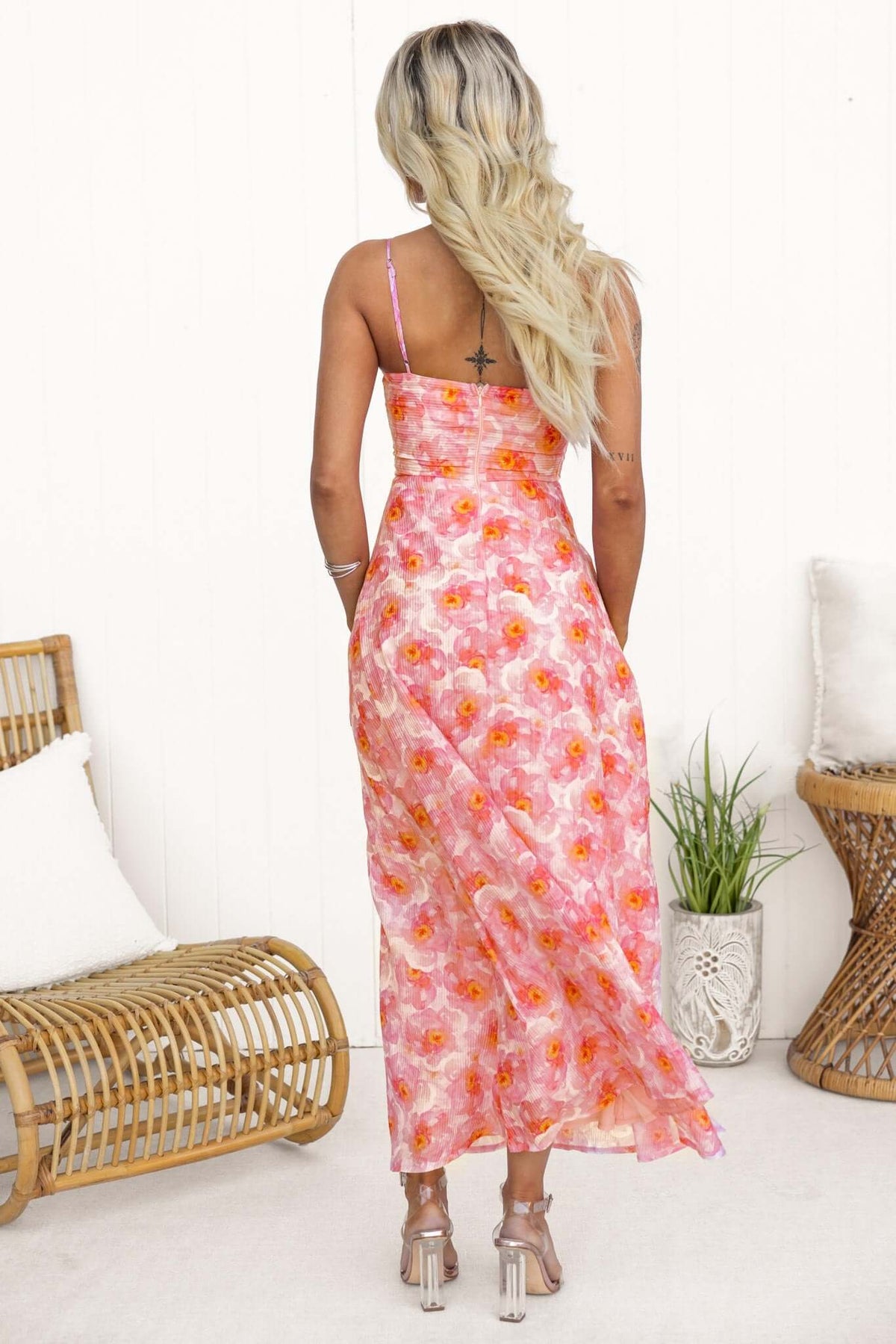 Back view of a model wearing the Denver Maxi Dress with adjustable straps and floral design in pink and orange.