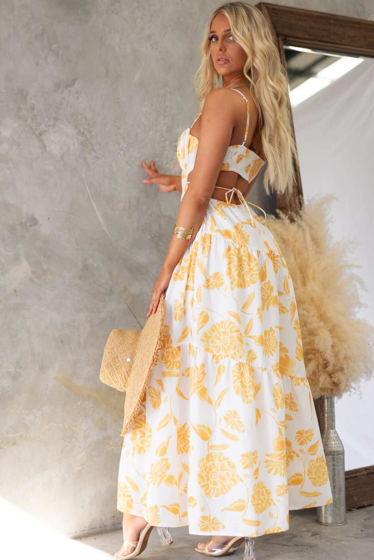 Odessa Maxi Dress in white and yellow floral pattern, featuring adjustable straps and a flowing skirt.
