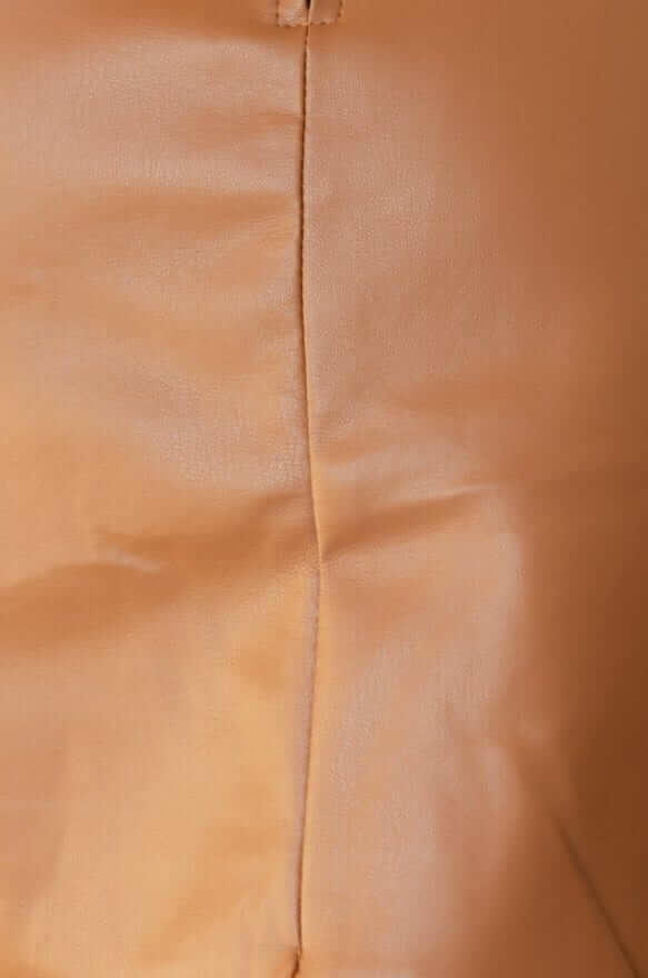 Close-up of faux leather fabric showing seam detail on the Rolla Skirt in a warm beige color.
