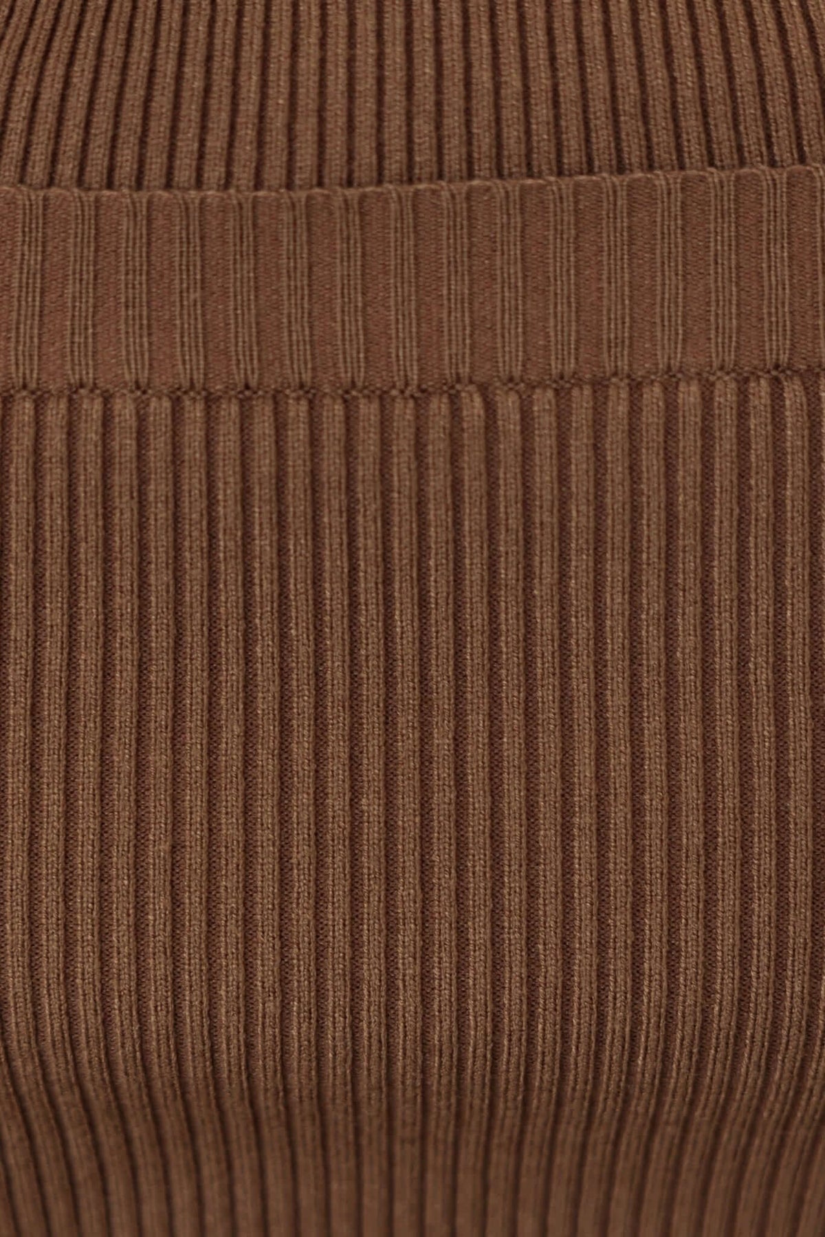 Close-up of ribbed knit fabric in rich brown color, showcasing texture and stretch for stylish apparel.