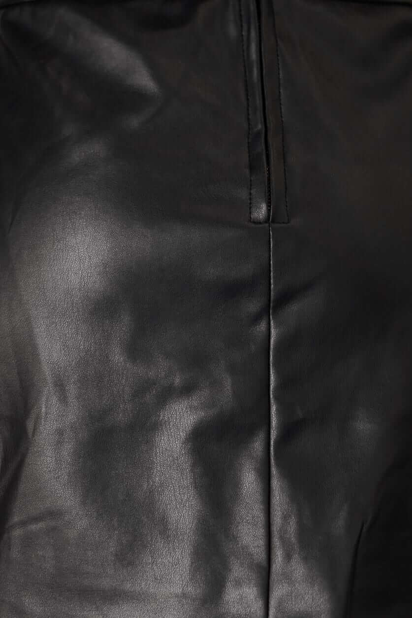 Close-up of the Rolla skirt's faux leather texture and back zip detail, featuring a sleek black design.