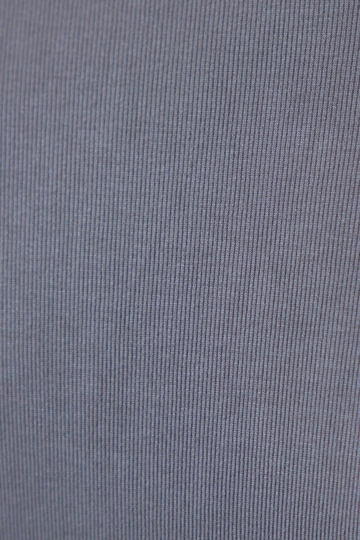 Close-up of the textured fabric of the Iletta Top, showcasing its ribbed pattern and soft stretch material.