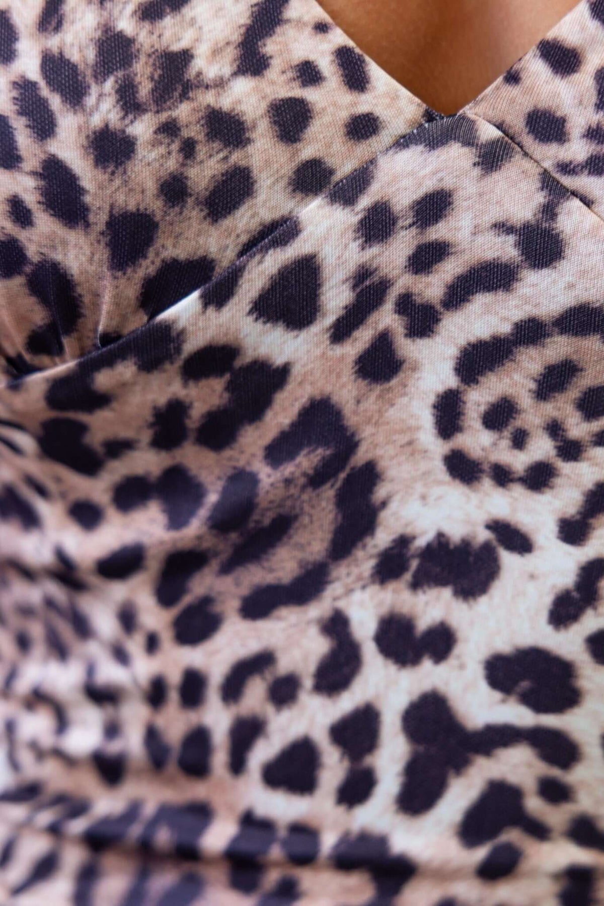Close-up of a leopard print fabric featuring a V-neckline, showcasing the texture and pattern of the Josefina Dress.