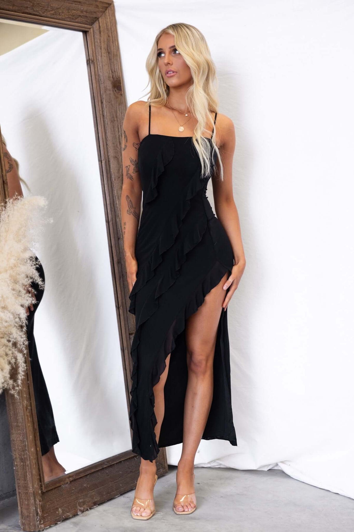 Black floral print Sharpay maxi dress with adjustable straps and front split, styled with a mirror backdrop.