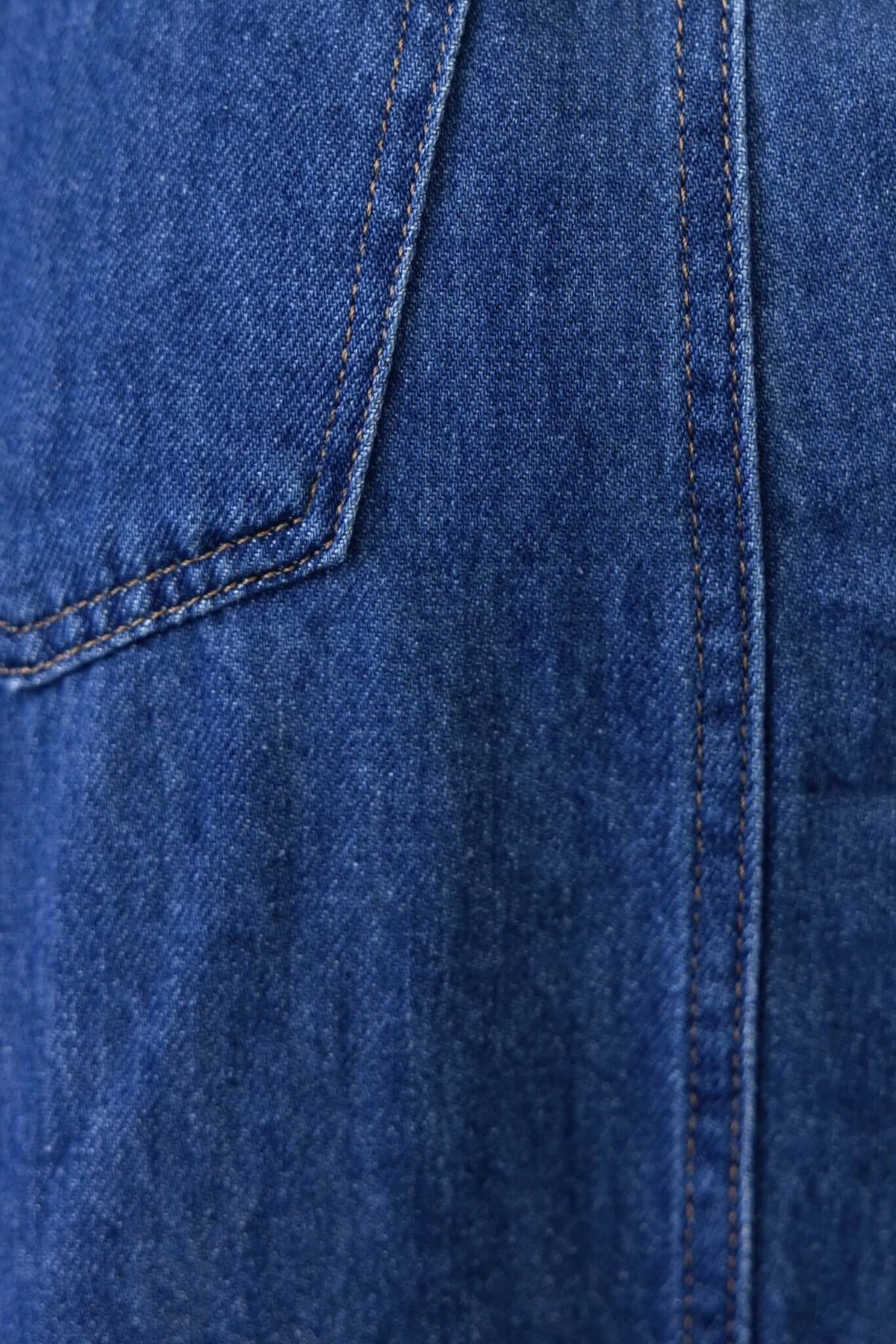 Close-up of Elwood Denim Maxi Dress fabric showing blue denim texture and stitching details.